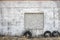White brick and concrete wall exterior texture outside with tires next to it.