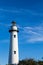 White Brick Lighthouse Rising From Green