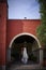 White bride dress hanging in red colonial hacienda, rustic weddings