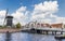 White bridge and historic windmill at a canal in Leiden