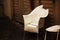 White broken plastic armchair on wooden wall with doors backgrund