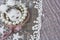 White brooch like head of hare with pink and bracelets on pink lace as background