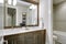 White and brown bathroom boasts a nook filled with double vanity