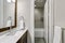 White and brown bathroom boasts a nook filled with double vanity