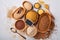 White, brown and red rice, buckwheat, millet, corn groats, quinoa and bulgur in wooden bowls on the light gray kitchen table. Glut