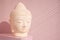 White Buddha bust on pastel pink background decorated with shades. Boho asian style. Relax mood. Yoga background