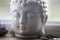 White Buddha head on the windowsill background. Home altar, spiritual ritual meditation place. Religion symbol, close up