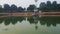 White buddha statue at the center of lake with water reflection at morning from flat angle