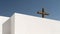 White building with a traditional cross set against a bright blue sky, AI-generated.