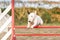 White bull terrier dog with a black ear jumping a fence in agility