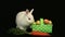 White bunny rabbit sniffing around a basket of easter eggs and a carrot
