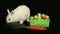 White bunny rabbit sniffing around a carrot and basket of easter eggs