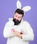 White bunny symbol of easter. Guy with toy and easter egg on violet background. Enjoy tenderness. Spring holiday. Easter