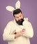 White bunny symbol of easter. Guy with toy and easter egg on violet background. Enjoy tenderness. Spring holiday. Easter