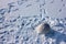 White buoy in a frozen river and people footprints on the fresh snow.