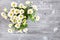 White bush chrysanthemums on a gray wooden table.