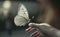 A white butterfly flies to a woman\\\'s hand, close-up macro generative AI
