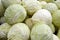 White cabbage heads stacked for sale at the groceries, big whole ripe round vegetables background - Calcium food, vitamins rich,