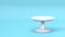 White cake stand 3d render on blue background. Empty dessert platter for birthday dishes. Plate tray podium for party.