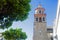 White campanile and orange tree, summer day