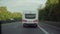 White camper trailer rides on road. Germany. Back view