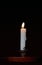 A white candle on a black background