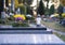 White candle burning in a glass lamp laid on the grave of All Saints Day