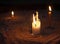 White Candles setting on the sand tray, lighting in the dark for religious ritual or spiritual, zen, meditation,