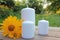 White candles and yellow flower on the wooden table in the summer garden