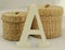 White capital letter A with two wicker baskets on white background