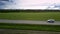 White car drives along damaged asphalt road bird eye view