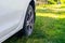 A white car is parked on the grass in the village. Close-up