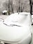 White car in snow with drawing smiley face on window. Happy and funny winter background. Snowy smile on car glass.