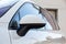 White car year front side mirror and windows view with nameplate diesel in excellent condition in a parking space among other cars