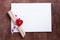 White card with a small red heart on wooden background.