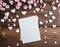 White card with white hearts and sakura branches on a wooden surface