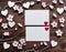 White card with white hearts and sakura branches on a wooden surface