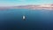 White cargo vessel sails crossing blue ocean against coast