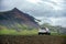 White cars parked on a dirt road The background is high mountains  in the countryside in Iceland