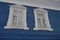 White carved architraves on the Windows of a blue wooden house