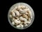White cashews, dry fruits, nuts in a glass jar isolated from black round vignettes frame, food photography