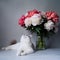 White cat near a bouquet of fresh peonies