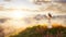 White caucasian adult woman standing in the meadows on top of a mountain