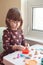 White Caucasian preschooler girl playing plasticine playdough indoors at home