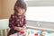 White Caucasian preschooler girl playing plasticine playdough indoors at home