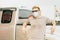 White caucasian wear virus facemask and stand at right of frame with placing arms on car while waiting for filling high energy