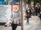 White Caucasian Young Woman, blonde, waiting in the streets of Prague, while another girl with a phone is standing behind