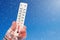 White celsius and fahrenheit scale thermometer in hand. Ambient temperature minus 15