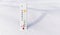 White celsius scale thermometer in the snow. Ambient temperature minus 21