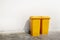 White cement wall background ,There is a yellow bins with a lid. Empty space for text.